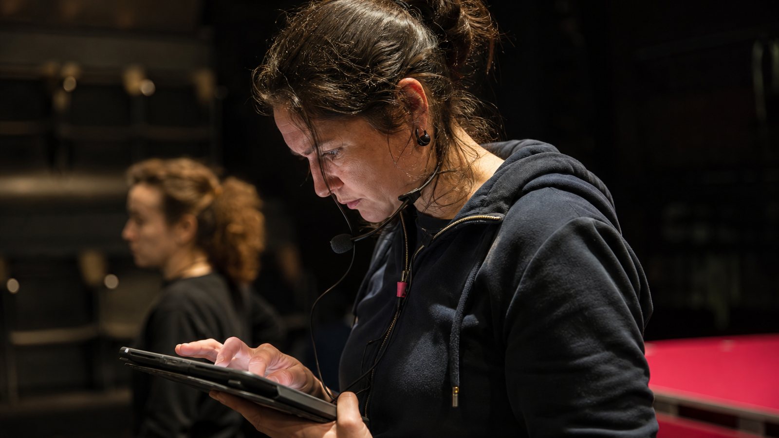 Équipe de spectacle consultant la même feuille de route partagée sur leurs téléphones en coulisses