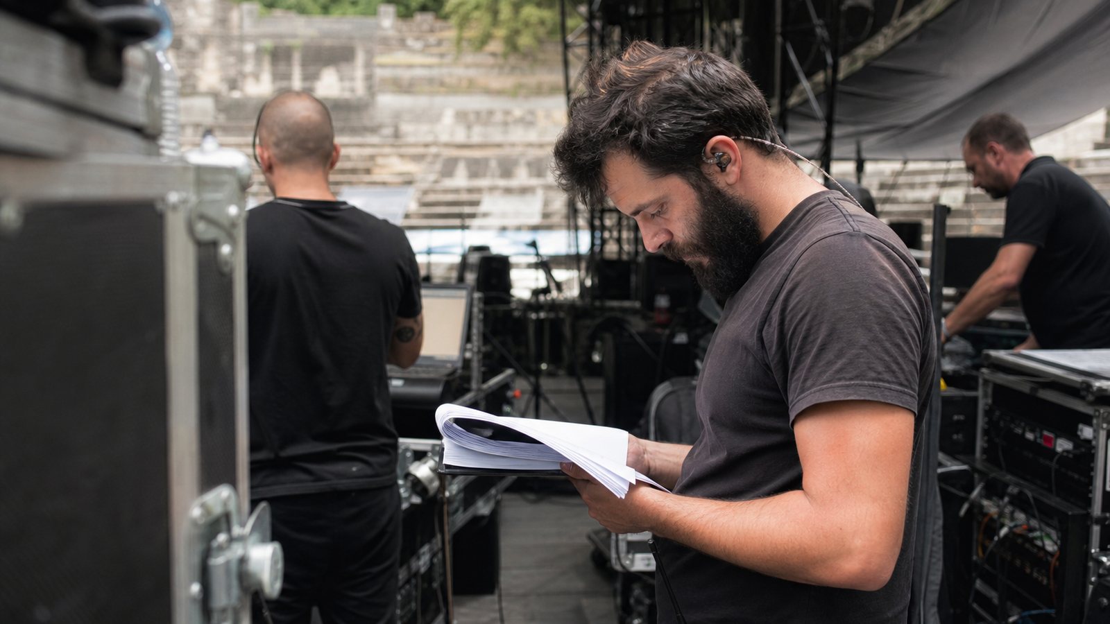 Régisseur consultant la feuille de route d'un concert sur une tablette en coulisses